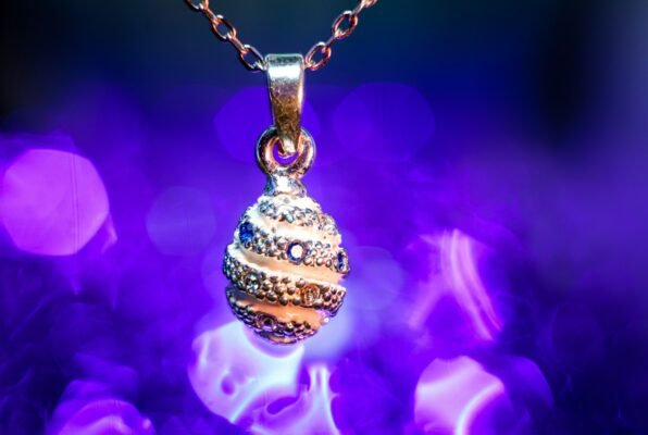 A gold necklace with a ball on a chain